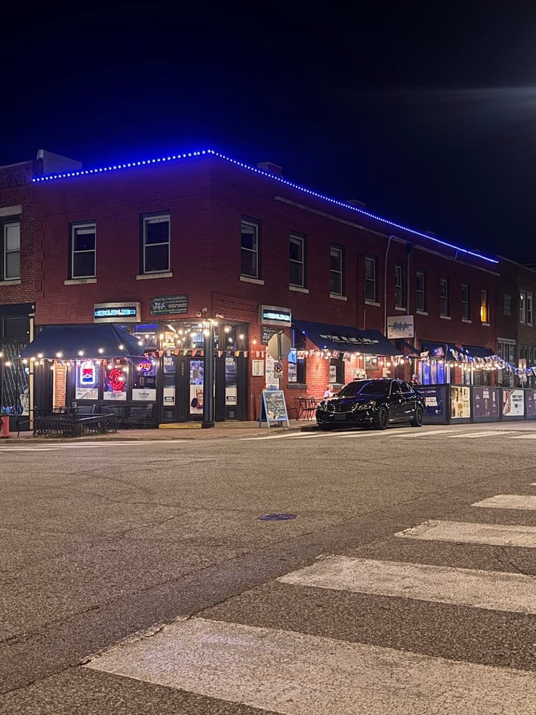 Red brick storefront building with blue neon roofline lighting illuminated at night