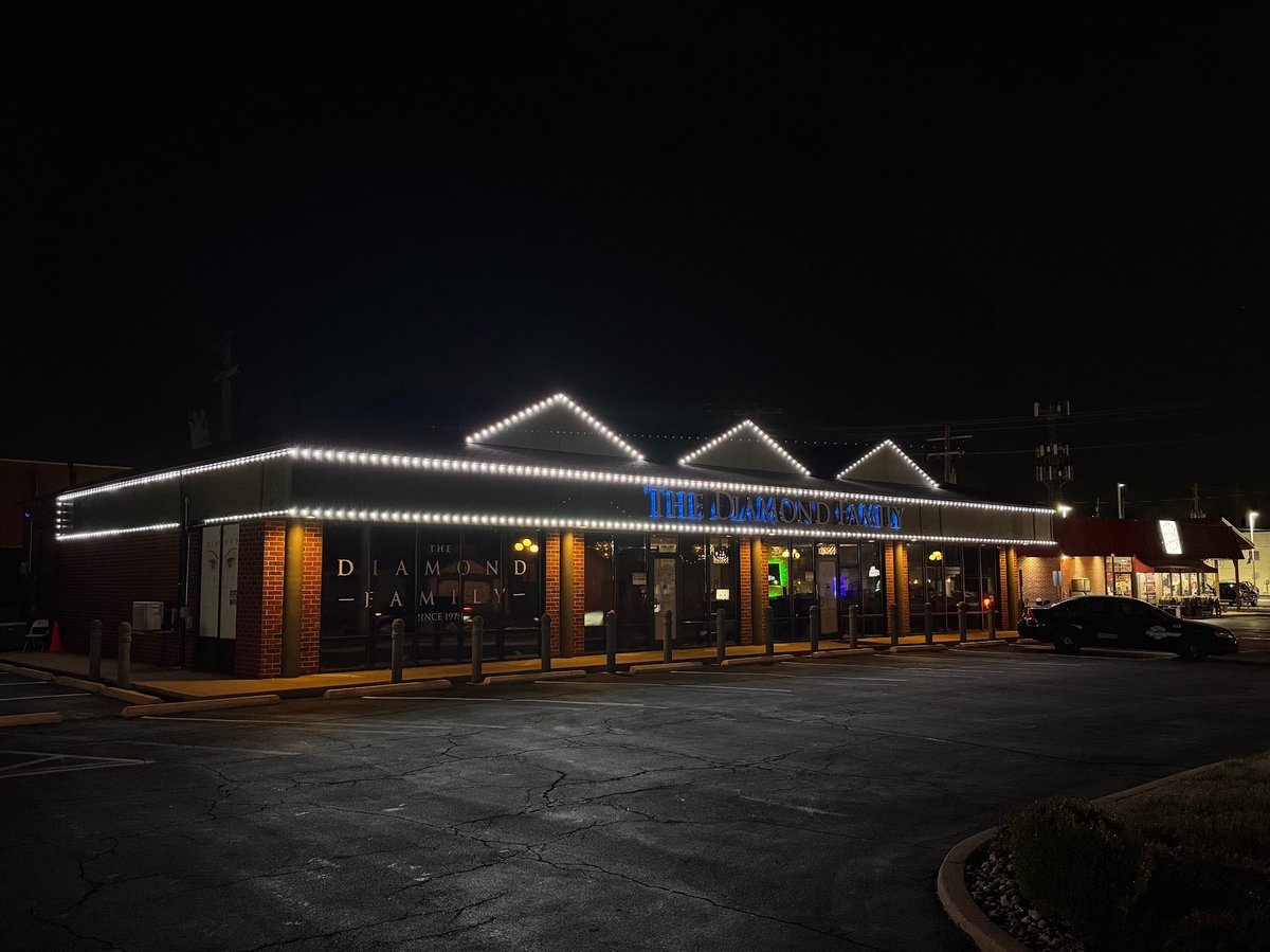 Illuminated retro-style diner building at night with white LED lights outlining the roof and storefront