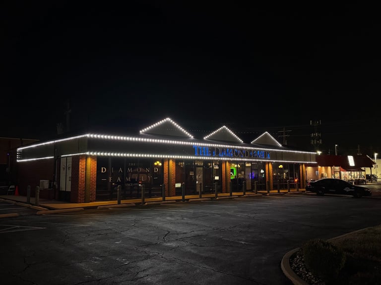 Illuminated retro-style diner building at night with white LED lights outlining the roof and storefront